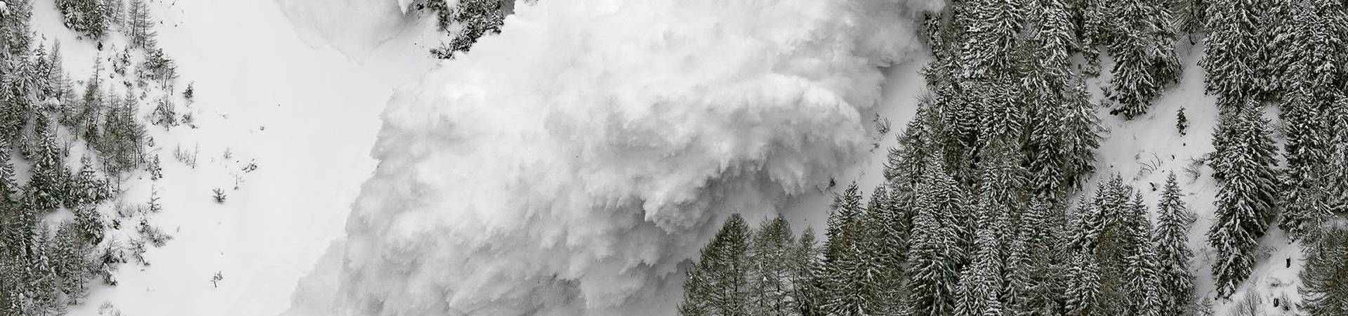 Avalanche occurs and large amount of snow slides down from the slope.