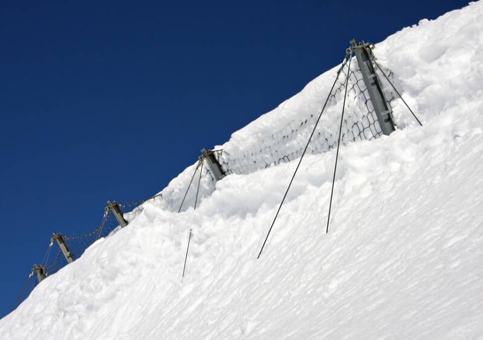 Avalanche is stopped by ring net system built on the slope.