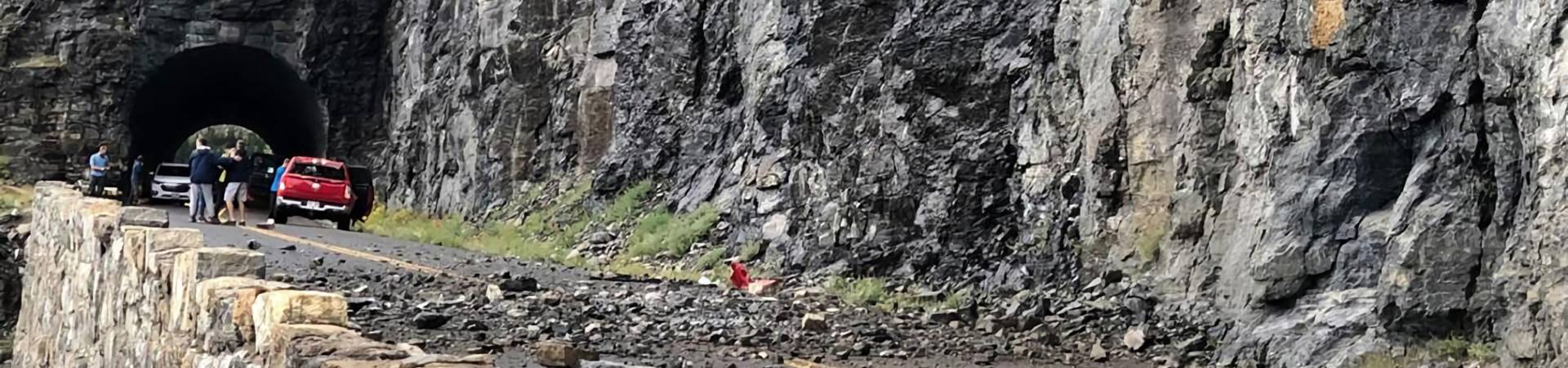 Rock falls onto the highway and interrupts the traffic.